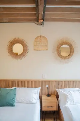 a bedroom with two beds and two mirrors on the wall at Candelaria Aparta Hotel Boutique in Medellín