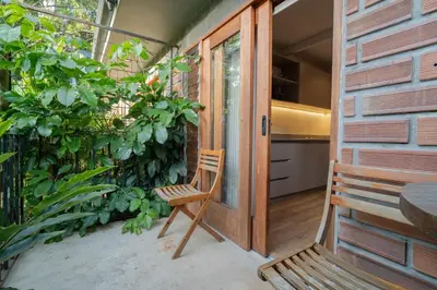 a porch with a wooden door and a chair at Candelaria Aparta Hotel Boutique in Medellín