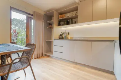 a kitchen with white cabinets and a table and chairs at Candelaria Aparta Hotel Boutique in Medellín