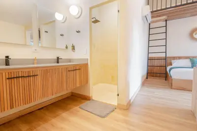 a bathroom with a sink and a shower and a bed at Candelaria Aparta Hotel Boutique in Medellín