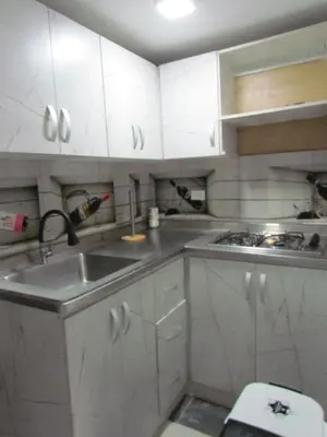 a kitchen with white cabinets and a sink at Comodo apartamento Niquia in Bello