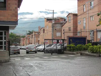 a city street with cars parked in a parking lot at Comodo apartamento Niquia in Bello