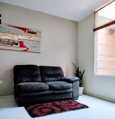a black leather couch in a living room with a rug at Apto 2 alcobas 2 baños 2 closet 2 camas dobles barrio cabañitas in Bello