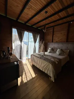 a bedroom with a bed and a large window at Glamping Mirador El Tunel in Estación El Salto
