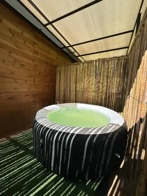 a jacuzzi tub in a room with a wooden wall at Glamping Mirador El Tunel in Estación El Salto