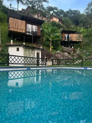 a large swimming pool in front of a house at Glamping Mirador El Tunel in Estación El Salto