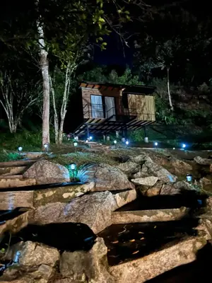 a cabin in the woods at night with lights at Glamping Mirador El Tunel in Estación El Salto