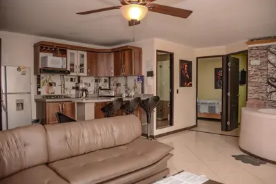 a living room with a couch and a kitchen at Calle 10 Suites in Medellín