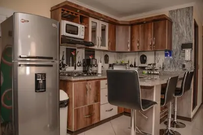 a kitchen with a stainless steel refrigerator and wooden cabinets at Calle 10 Suites in Medellín