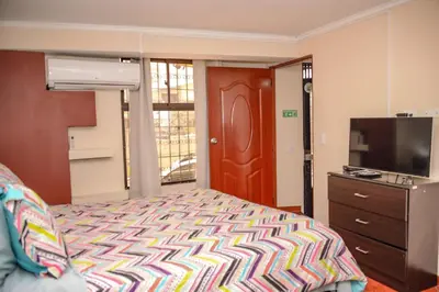 a bedroom with a bed and a flat screen tv at Calle 10 Suites in Medellín