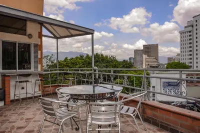 a patio with a table and chairs on a balcony at Calle 10 Suites in Medellín