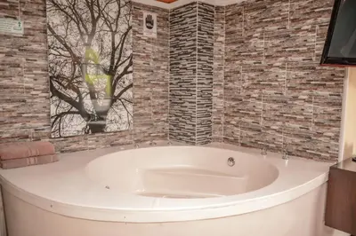 a bath tub in a bathroom with brick walls at Calle 10 Suites in Medellín