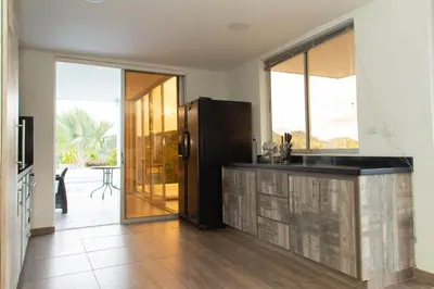 a kitchen with a counter and a refrigerator in a room at Casa de Campo Monblack in El Peñol