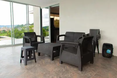 a group of chairs and tables in a room with windows at Casa de Campo Monblack in El Peñol