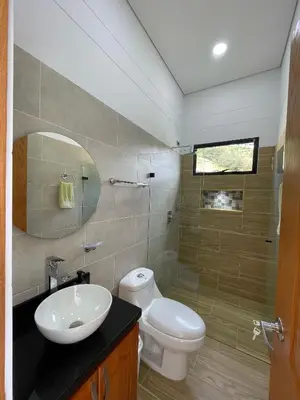 a bathroom with a toilet and a sink and a mirror at Casa de Campo Monblack in El Peñol