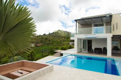 a villa with a swimming pool in front of a house at Casa de Campo Monblack in El Peñol