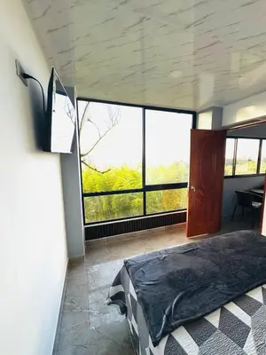 a bedroom with a bed and a large window at Hermosa Cabaña en El Peñol in Chiquinquirá