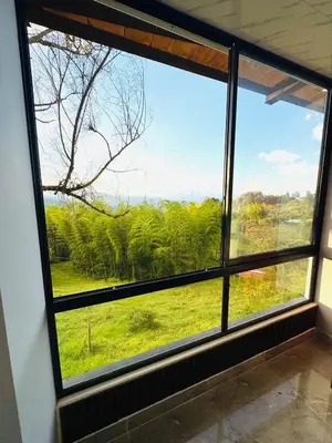 a window with a view of a green field at Hermosa Cabaña en El Peñol in Chiquinquirá