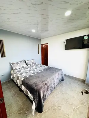 a bedroom with a bed and a tv on the wall at Hermosa Cabaña en El Peñol in Chiquinquirá