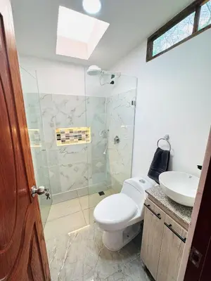 a bathroom with a shower and a toilet and a sink at Hermosa Cabaña en El Peñol in Chiquinquirá
