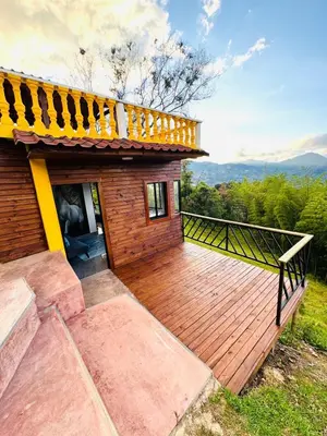a house with a wooden deck with a balcony at Hermosa Cabaña en El Peñol in Chiquinquirá