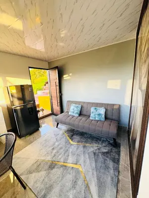 a living room with a couch and a refrigerator at Hermosa Cabaña en El Peñol in Chiquinquirá