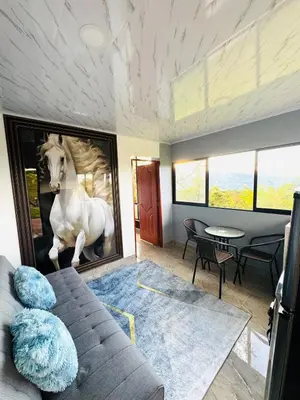 a living room with a couch and a painting of a horse at Hermosa Cabaña en El Peñol in Chiquinquirá