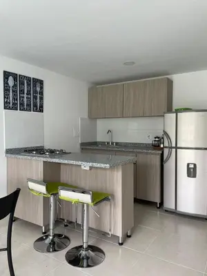 a kitchen with a counter and a refrigerator and stools at CC Fundadores, cerca sector el Cable y CC Mall Plaza in Manizales