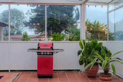 a red stove in a room with plants and windows at Country Western State in Marinilla