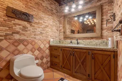 a bathroom with a toilet and a sink and a mirror at Country Western State in Marinilla