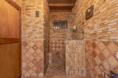 a bathroom with a shower in a brick wall at Country Western State in Marinilla