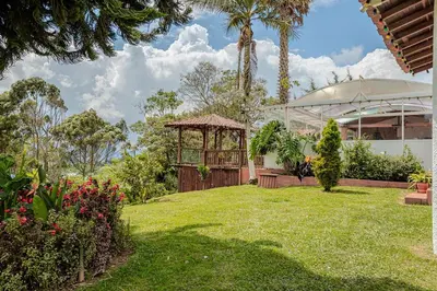 a garden with a gazebo and a building at Country Western State in Marinilla