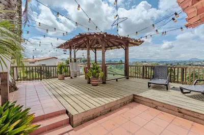 a wooden deck with a gazebo and a bench at Country Western State in Marinilla