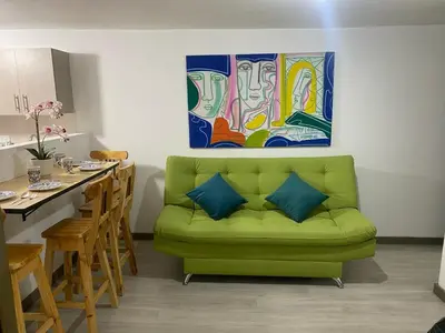 a living room with a green couch and a table at Hermoso y cómodo apartamento 4 habitaciones cerca al Viva Envigado in Envigado