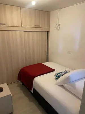 a bedroom with a bed with a red blanket on it at Hermoso y cómodo apartamento 4 habitaciones cerca al Viva Envigado in Envigado
