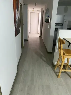 a hallway with a table and a wooden chair at Hermoso y cómodo apartamento 4 habitaciones cerca al Viva Envigado in Envigado