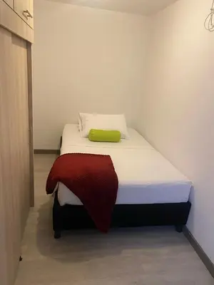 a small bedroom with a bed with a green blanket on it at Hermoso y cómodo apartamento 4 habitaciones cerca al Viva Envigado in Envigado