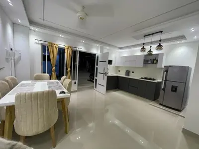 a kitchen and dining room with a table and a refrigerator at Class Suite Apartamento Doradal in Doradal