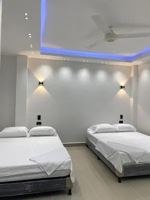 two beds in a room with a blue ceiling at Class Suite Apartamento Doradal in Doradal