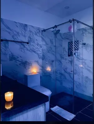 a bathroom with a toilet and a glass shower at Class Suite Apartamento Doradal in Doradal