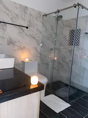 a bathroom with a shower with a toilet and a sink at Class Suite Apartamento Doradal in Doradal