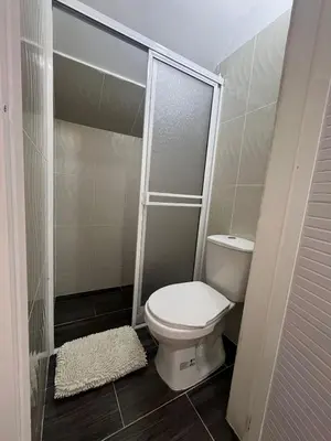 a small bathroom with a toilet and a shower at Class Suite Apartamento Doradal in Doradal