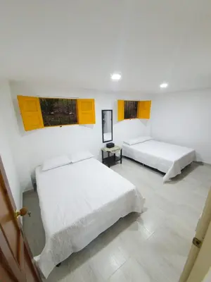 two beds in a white room with yellow windows at Villa Andrea Apartamento de lujo en Jericó Antioquia para 7 personas in Jericó
