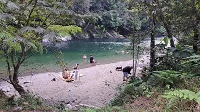 a group of people on a beach near a river at Casa Borojó, Refugio Natural Jacaranda in Cocorná