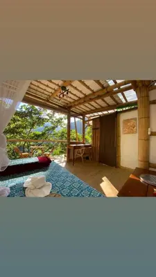 a room with a bed and a table in it at Casa Borojó, Refugio Natural Jacaranda in Cocorná