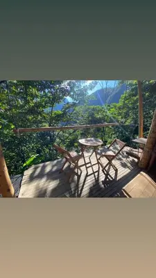 a patio with a table and chairs on a balcony at Casa Borojó, Refugio Natural Jacaranda in Cocorná