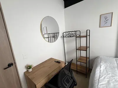 a bedroom with a desk and a mirror and a bed at New apartment in Belén in Medellín
