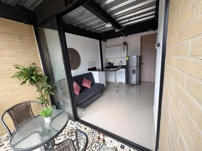 a balcony with a glass table and a kitchen at New apartment in Belén in Medellín