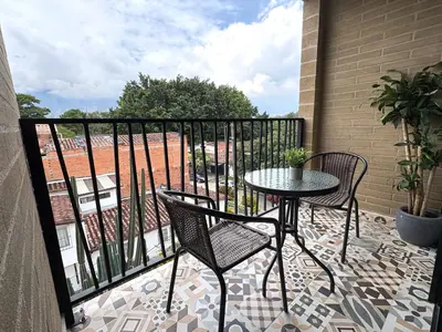 a patio with a table and chairs on a balcony at New apartment in Belén in Medellín