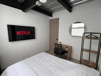 a bedroom with a bed with a netflix sign on the wall at New apartment in Belén in Medellín